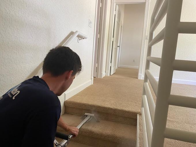Everclean team member steam cleaning carpeted stairs